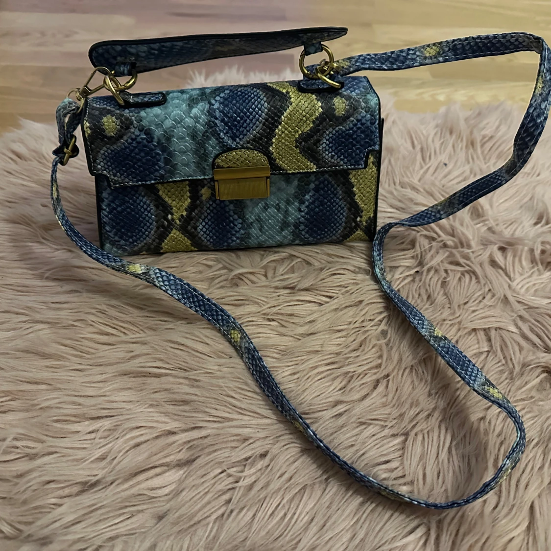 Ormmönstrad axelväska med gulddetaljer