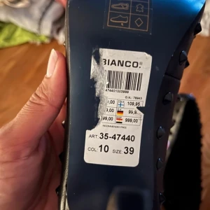 Svarta pumps med nitar från Bianco - Snygga svarta pumps från Bianco med spetsig tå och klack. Skorna är dekorerade med nitar för en edgy look. Perfekta för att ge din outfit en tuffare stil.