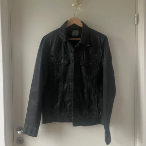 Jeansjacka från Lee - Snygg svart jeansjacka från Lee i storlek S. Jackan har en klassisk design med knappar framtill och två bröstfickor. 