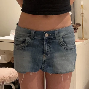 Blå jeanskjol - Snygg blå jeanskjol som är väldigt kort! Slitningar i kanterna, köpt på Vinted men passade ej💘