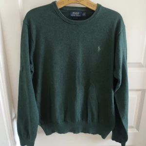  Ralph Lauren grön pullover / bomullströja  - Stilren pullover / bomullströja från Ralph Lauren. Riktigt snygg mörkgrön färg med grön logga. Stl S, se mått. Mycket fint skick, inga hål eller fläckar.  Mått: Armhåla till armhåla 55cm, bredd längst ner 38cm ostretchat, längd från mitt på axeln 62cm.