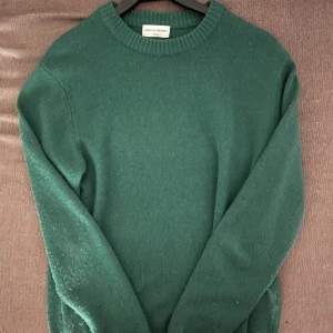 Grön stickad tröja från These Glory Days - Säljer en snygg grön stickad tröja från These Glory Days. Tröjan har en klassisk rund halsringning och långa ärmar, perfekt för kyligare dagar mot våren. Den är mjuk och bekväm, idealisk för både vardag och avslappnade tillfällen. Slutsåld överallt, Nypris 899kr. Mitt pris 399kr! Vid fler frågar är det bara att skriva!