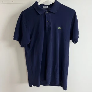 Lacoste pike  - Säljer min riktig snygga Lacoste pike den har blivit använd ganska mycket men den är fortfarande i bra skick men har ett hål i högra armhålan (jätte litet). Tveka inte att ställa frågor om du har några. Pris går att diskuteras