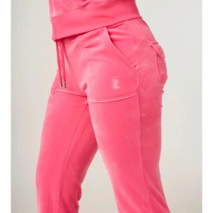 Rosa juicy byxor - Juicy byxor i färgen Hot pink. Storlek M men mer som en S!!! Säljer pågrund av att jag inte använder som längre. Det saknar en av metal bitarna på snöret(se sista bilden)