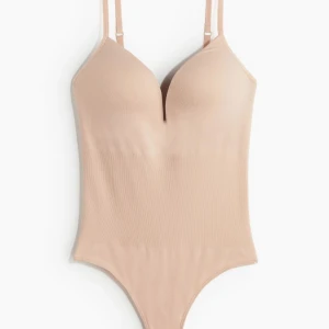 Beige body från h&m - säljer denna snygga & virala beige bodysuit med smala axelband och djup urringning. säljer den pga den va lite för liten! 💞 endast testad! 