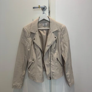 Beige skinnjacka från ONLY (ej äkta skinn) - Beige/ljusgrå skinnjacka från ONLY med dragkedjor. Storlek 36.  Nästan aldrig använd. 