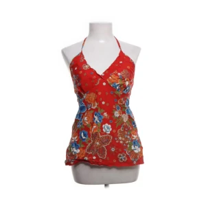 Röd blommig halterneck topp - Superhärlig röd halterneck topp med ett blommigt mönster perfekt till sommaren eller utomlands! 🌺Storlek M men passar även S, snörningen i nacken går att knytas hur man vill 💕 Finns en liten slit längst ner på båda sidorna ✨Inga defekter förekommer. Skriv privat om du har några funderingar 💖