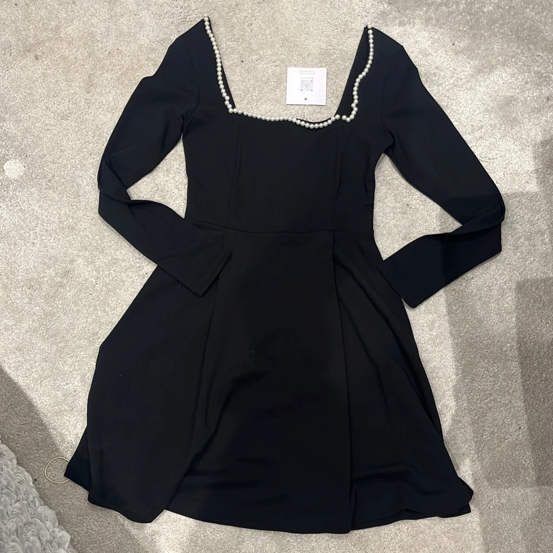 Svart klänning med pärldetaljer