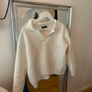 Vit ribbad tröja från SHEIN - Säljer en stilren vit ribbad tröja från SHEIN. Tröjan har en v-ringad krage och långa ärmar, perfekt för en avslappnad look. Den är mjuk och bekväm, idealisk för kyligare dagar.