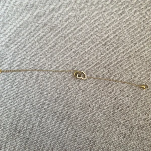 Guldarmband med hjärta och stenar - Elegant guldarmband med ett hjärta dekorerat med glittrande stenar. Hjärtat är sammanflätat med en cirkel, vilket ger en unik och stilren design. Perfekt för att ge en touch av glamour till din outfit.