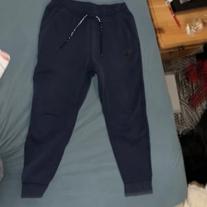 Blå nike tech byxor - Nike tech byxor i storlek M men passar även S