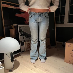 Blå bootcut jeans - Snygga blå bootcut jeans med en klassisk look. De har en lågmidjad passform och är perfekta för en avslappnad stil. Jeansen har en dragkedja och knappar framtill.