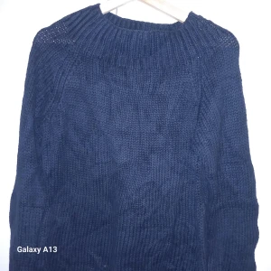 Mörkblå stickad tröja från Ralph Lauren - Säljer en stilren mörkblå stickad tröja från Ralph Lauren. Tröjan har en klassisk design med ribbad krage och långa ärmar, perfekt för kyligare dagar. Passar bra till både jeans och chinos.