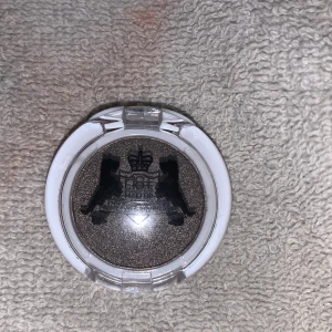 Chromatic ögonskugga från Hot Makeup. använd 1 gång  - Snygg och glittrig ögonskugga i en mörk, skimrande nyans från Hot Makeup. Perfekt för att skapa en dramatisk look. Kommer i en praktisk rund förpackning med genomskinligt lock.