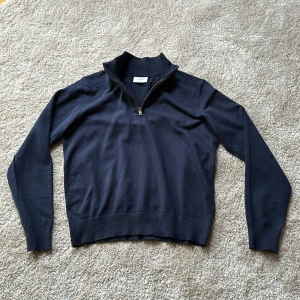 Mörkblå halfzip Grunt - Säljer en stilren mörkblå halfzip från Grunt i storlek XL. Tillverkad i ett mjukt material. Perfekt för kyligare dagar. Nypris: 1200kr