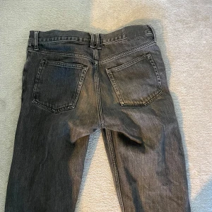 Svarta jeansbyxor - Snygga svarta jeansbyxor med klassisk femficksdesign och knappgylf. Perfekta för en avslappnad stil. Passar bra till både t-shirt och skjorta. De är från weekday och är i storlek 29/30