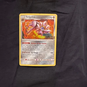 Solgaleo Pokémon-kort från Cosmic Eclipse - Säljer ett Solgaleo Pokémon-kort från expansionen Cosmic Eclipse. Kortet har en färgstark illustration av Solgaleo med eldiga detaljer. Det har 170 HP och förmågor som 'Armor of the Sunne' och 'Sol Fangs'. Perfekt för samlare eller spelare som vill stärka sin kortlek.