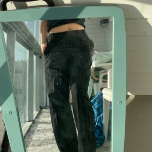 Svarta randiga byxor - Snygga svarta byxor med diskreta ränder. Byxorna har en loose passform och jag är 160 cm. De är tillverkade i ett bekvämt material som ger en skön känsla hela dagen.