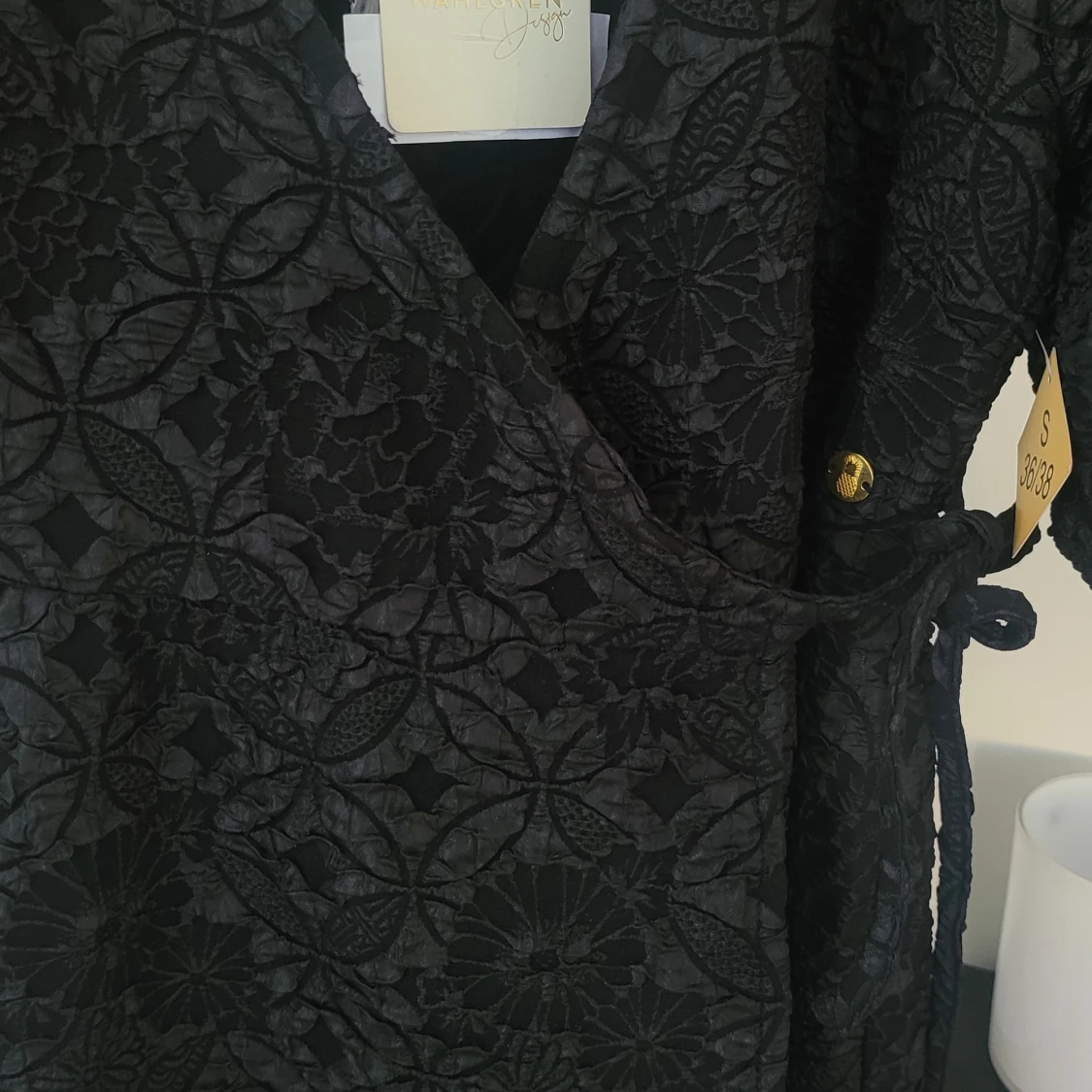 Svart omlottklänning med blommigt mönster - 1