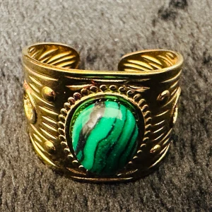 Bohemian Gold-Toned Ring with Green Stone – Adjustable & Elegant! - Elegant, justerbar ring i guldtonad metall med en vacker grön sten (troligen malakit). Ringen har en bohemisk/vintage-inspirerad design med fina detaljer. Perfekt för att ge din stil en unik touch!  Storlek: Justerbar Material: Guldtonad metall, sten (förmodligen malakit) Skick: Mycket bra skick  Skicka meddelande vid frågor!  Elegant, adjustable ring in gold-toned metal with a beautiful green stone (likely malachite). The ring features a bohemian/vintage-inspired design with fine details. 