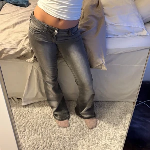 Grå bootcut jeans - Säljer mina skitSnygga grå bootcut jeans från Weekday med låg midja och tvättad look med en grön knappdetalj vid fickan. Perfekta för vardags eller fest med en snygg topp. Har inte mått, storlek 27/30. Jag bär oftast 34 i midja och har 80 i innerben