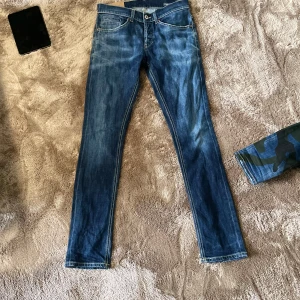 Dondup jeans - Snygga blå jeans med en klassisk femficksdesign och knappgylf. De har en lätt tvättad look och kontrastsömmar som ger en cool stil. Perfekta för en avslappnad vardagslook. Knappt använda!