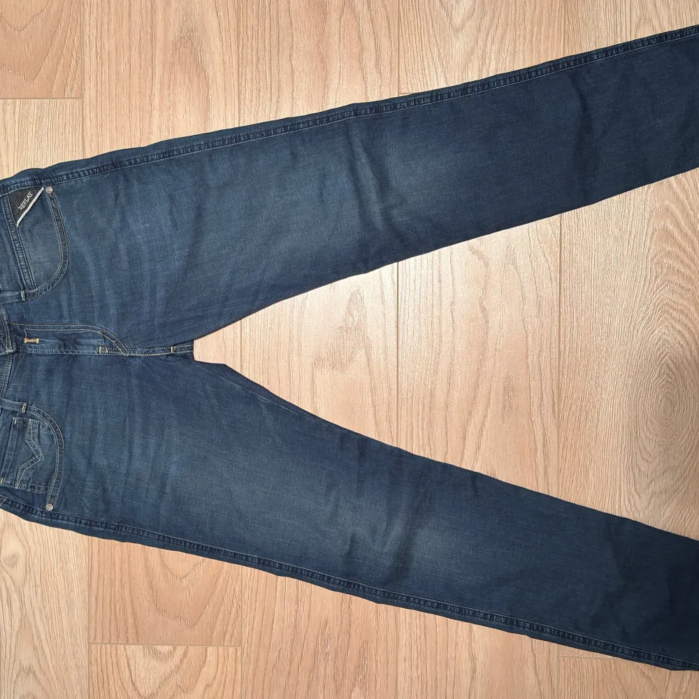 Snygga mörkblå jeans från Replay med klassisk femficksdesign och en läderpatch med logga på baksidan. Jeansen har en slim passform och är perfekta för en stilren look. De är tillverkade i ett bekvämt denimtyg som ger en skön känsla hela dagen. Modellen heter anbass och storleken är 29/32. Farkut & Housut.