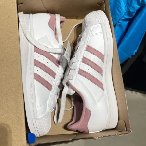 Adidas Superstar i vitt och rosa - Adidas skor, använt några gånger men inga slitage alls på dem. Är du intresserad är de bara å fråga på om bilder å allt💕