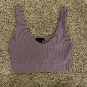 Lila ribbad topp  - Säljer en snygg lila ribbad tooo. Toppen har en v-ringad design och är ärmlös, perfekt för varma dagar. Fraktar endast varan och köparen betalar frakten! Priset som syns är vad som gäller🙏🫶