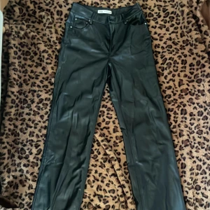 Svarta skinnbyxor från Zara - Snygga svarta skinnbyxor från Zara med en stilren design. Byxorna har en rak passform.