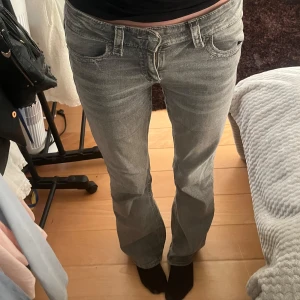 Grå bootcut jeans - Snygga grå bootcut jeans med låg midja och klassisk femficksdesign. Jeansen har dekorativa sömmar på bakfickorna och en bekväm passform. Älskar detaljerna på dessa men används tyvärr inte så därav säljer jag!