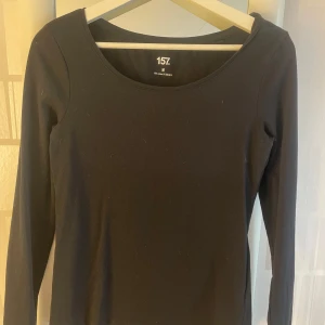 Svart långärmad topp från 157 - Säljer en stilren svart långärmad topp från 157. Tillverkad i en mjuk bomullsblandning med elastan för extra komfort. Perfekt basplagg för alla tillfällen. 🖤
