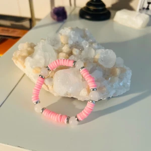 Rosa pärlarmband med vita detaljer - Säljer ett supergulligt armband med rosa och vita pärlor. Armbandet har små silverfärgade detaljer som ger det en extra touch. Perfekt för att liva upp vilken outfit som helst! 💖