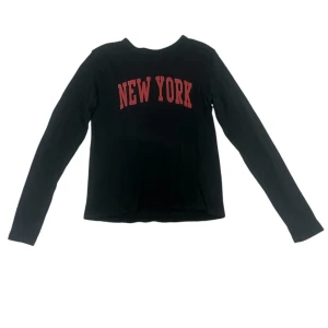 Svart långärmad tröja med New York-tryck - Säljer en svart långärmad tröja från Brandy Melville med rött 'New York'-tryck. One size men tror den kan passa allt från xs-m. Kan skicka mått privat💞 Andra bilden är tagen från Brandys hemsida.