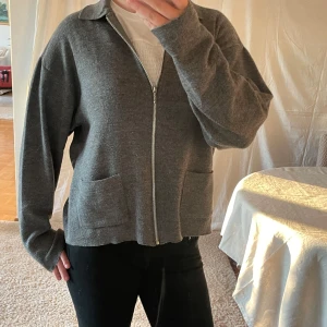 Grå stickad kofta med dragkedja  - Bra skick, aldrig använd och framfickor. 