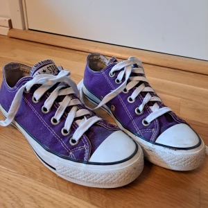 Lila converse skor (tillköpta skosnören) - Säljer fina mörklila låga converseskor som är köpta på erikshjälpen men därefter knappt använda. Man kan se att de har använts förr men inget större som syns, utom litet upprivet hål på insidan vid hälen på ena skon. Skriv för pris och fler bilder!