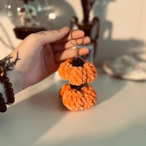 Handgjord nyckelring med orange pumpa - Superfin handgjord nyckelring formad som en orange pumpa. Perfekt för höst och Halloween! Den är gjord av mjukt garn och har en liten kedja för att fästa på nycklar eller väska. En unik och söt accessoar för att ge lite höstkänsla till dina saker.