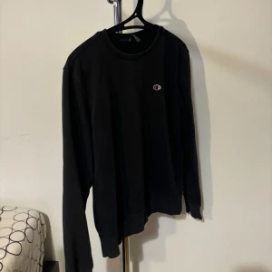 Svart långärmad tröja från Champion - Säljer en stilren svart långärmad tröja från Champion. Perfekt för både vardag och träning. Den har en liten Champion-logga på bröstet och är i bra skick. Passar till allt och är superbekväm! Använd flera gånger! Nypris 249kr