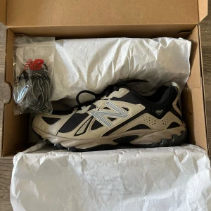 New Balance 610 Svart Beige - Svarta och beigea New Balance 610. Endast använda 3-4 gånger så skicket är mycket bra! Storlek 44. Orginalkartongen följer med samt ett par matchande skosnören. Nypris: 1295kr Mitt pris går självklart att diskutera och vill du se fler bilder finns de