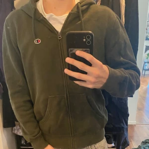 Grön Champion Zip Hoodie - Grön Zip Hoodie i Storlek S från champion Passar nog även M fast lite tight.  Pris går att diskuteras