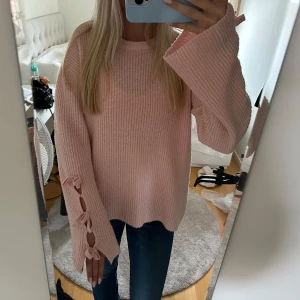 Rosa stickad tröja med knytband - Säljer en superfin rosa stickad tröja som är perfekt för höst och vinter. Den har långa ärmar med snygga knytband som detalj vid ärmsluten. 💖 passar mig med storlek S!