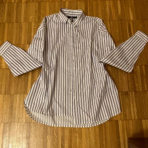 Randig skjorta  - En randig skjorta som är blå, röd och vit. Aldrig använd, helt ny, fick den i present. Den är lite baggy så den sitter inte fast med kroppen. Om man gillar baggy kläder så rekommenderar jag