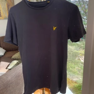 Svart Lyle&scott T-shirt - Säljer nu denna sjukt snygga Lyle&scott T-shirten i storlek S. Tröjan är i fint skick utöver ett litet hål som knappt är synligt (kolla bild 4). Hör av dig om du har fler frågor!