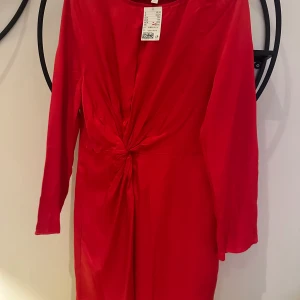 Röd klänning - Säljer denna röda klänningen från H&M med prislappen kvar. Storlek 36. Klänningen slutar precis ovanför knäna (jag är 170 cm lång).