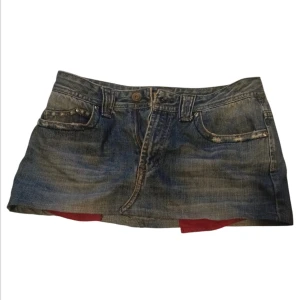 Jeanskjol i blå denim - Säljer en cool jeanskjol i blå denim med klassisk femficksdesign. Kjolen har en kort längd och en knapp- och dragkedjestängning framtill.  Storlek står inte men jag är s-m och den passar