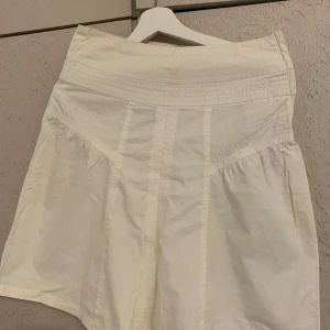 Vit kjol från Vero Moda - Säljer en superfin vit kjol från Vero Moda i storlek 36. Kjolen har en enkel och stilren design med en hög midja och lätt utställd form. Perfekt för sommardagar eller en avslappnad vårlook. Materialet känns lätt och bekvämt. Passar både till vardags och festligare tillfällen!