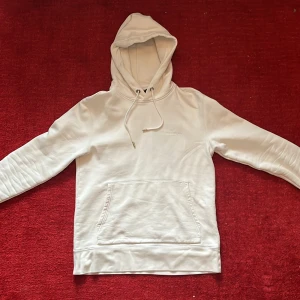 J.lindeberg hoodie - Säljer denna vita hoodie från J.lindeberg. Hoodie är sparsamt använd så därav är den i ett mycket bra skick. Nypris: 1500
