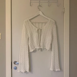 Vit spets kofta - Vit spetskofta med knyte och utsvängda lettuce edge ärmar. Vet tyvärr inte var den ursprungligen kommer ifrån då lapp saknas och jag köpt denna second hand. Passar XS/S.  Det finns någon liten defekt men annars mycket fin💗