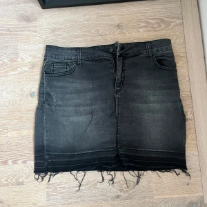 Svart jeanskjol från Systemaction - Snygg svart jeanskjol från Systemaction i kort modell. Kjolen har en rå kant nertill som ger en cool och avslappnad look. Perfekt för både vardag och fest! 🖤 skriv för fler bilder eller frågor❤️