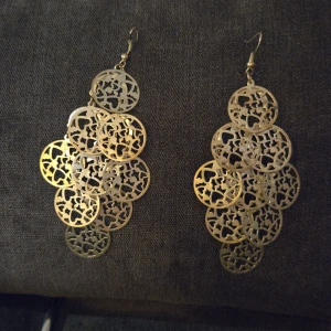 Silverfärgade örhängen med mönstrade cirklar - Snygga silvriga örhängen med flera sammanlänkade cirklar som har ett fint, utskuret mönster. Perfekta för att ge en elegant touch till din outfit, oavsett om det är för en fest eller en utekväll. De är lätta och bekväma att bära hela dagen.